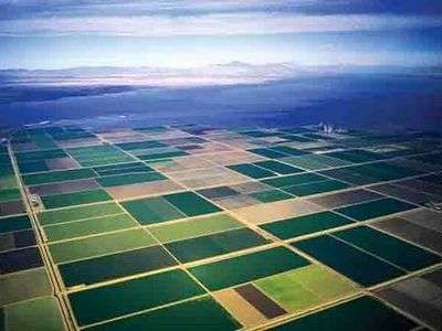 Aerial shot of farm fields with a large body of water in the background