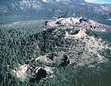 Two craters in a forested area and one crater on top of a large hill. A hummocky massive but flat hill is in the background.