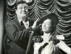 Jackie Gleason straightening a dancer's hat