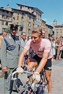 Cyclist wearing a pink jersey while on a bike.