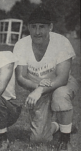 A picture of John Brickels kneeling on the grass from a 1946 Cleveland Browns game program