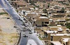 An aerial view of the area surrounding the Jordanian embassy after the bombings.  Burnt out cars and debris are visible.