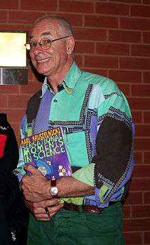 Karl Kruszelnicki holding a copy of his book Sensational Moments in Science