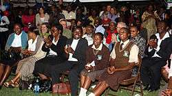 Audience seated in rows, smiling and clapping