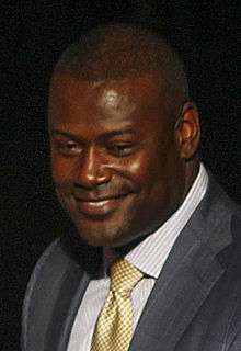 Color head-and-shoulders photograph of smiling African-American man (Kevin Carter) in suit and tie.