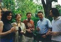 Five happy-looking people at a lawn party.