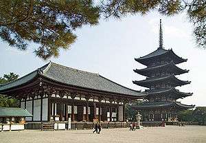 A large building with wooden beams and white walls.