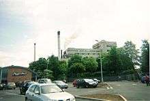 Parking lot, with a factory and a Pizza Hut in the background