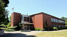 A side view of Lincoln High School—a brick, two-storey building with an American flag