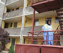 Ethiopian woman involved in PGI's pilot testing in Addis Ababa, Ethiopia, standing outside of her low income housing complex