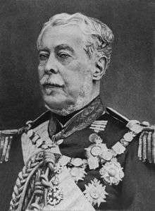 Half-length photographic portrait of an older man dressed in a military tunic with medals, chain of office and sash