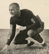 Bomar squatting down with his hand in the dirt