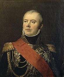 Portrait of a slightly balding man taking an heroic pose with his head tilted back. He wears a dark blue marshal's uniform with elaborate gold braid and a large red sash across his right shoulder.