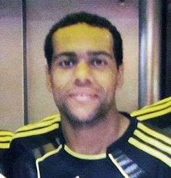 An Afro-Brazilian man smiling and posing for the camera.