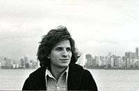 Determined-looking young man against city skyline.