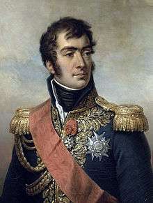 Painting of a clean-shaven man with dark hair and long sideburns. He wears a dark blue military uniform with gold epaulettes, high collar, elaborate lace, two medals and a velvet red sash.