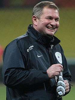 A laughing middle-aged white man wearing a lightweight outdoor jacket.