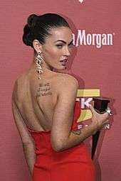 Photograph showing Megan Fox's tattoo of the quote "We will all laugh at gilded butterflies" and a partial view of her tattoo of Marilyn Monroe's face