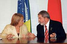 Woman and man in intense conversation at conference table.