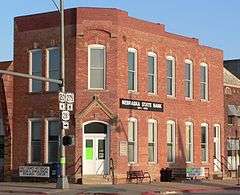 Two-story brick building; sign reading "Nebraska State Bank"; sign reading "Holt County Historical Museum and Genealogical Research Center"