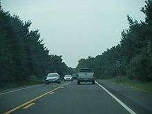 A two lane road in a wooded area with a south Route 347 sign on the right side of the road