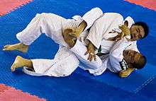 A grappler applies a lock to his opponent's neck