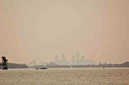 View across a lake to a silhoutted skyline of a major city