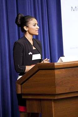 Davuluri standing at a podium