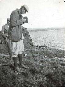 Photograph by R.C. MacLeod showing a man taking a photograph with a hand-held camera.