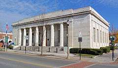 A light-colored rectangular stone building with a recessed colonnaded front entrance. The words "Bennington, Vermont" are legible in lettering on the right side