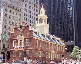 Colonial style red brick building with a white cupola in an urban setting