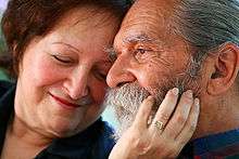 A woman touches a man's face.