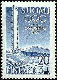 A soild blue background is intruded on its left side by a structure, shaded in white, representing the tower and stand of the Helsinki Olympic Stadium. The Olympic rings, also white, lie at the top of the blue background, partly obscured by the stadium's tower. The word "1952" is written in white in the middle of the blue background, while "XV Olympia Helsinki" is written in blue, beneath the image.