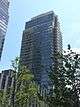 One Northside Piers, a high-rise clad in blue-gray glass, viewed from an adjacent plaza