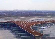 Overhead view of airport terminal, with planes at the gate and on the tarmac