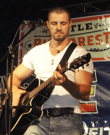 Pavel Stratan playing a guitar on stage.