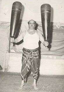 The pahlevan Mustafa Tousi holding a pair of meels