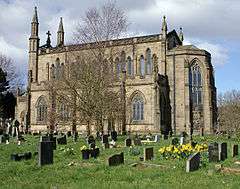 A stone church with a tall clerestory, polygonal apse, pinnacles and turrets, but no tower.