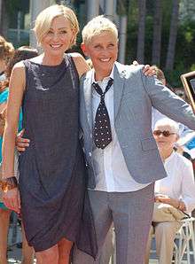 Portia de Rossi and Ellen DeGeneres smiling at an event.