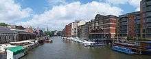 The view north from Redcliffe Bridge, showing one yellow water taxi, warehouses and various buildings along Welsh Back