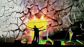 In this scene, Waters punches the wall, while the projections simulate the wall crumbling as a result, revealing a bright sunset behind