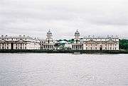 A view of a city coastline populated by white buildings with renaissance-era influences.