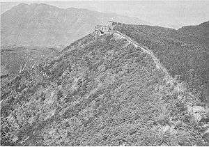 A hill top lined with stone walls and crumbling fortifications