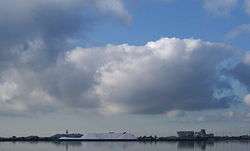 Clouds in the sky and in the distance piles of salt