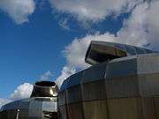 The upper half of the drums featuring the formerly rotatable tops. A deep blue sky featuring wispy clouds is seen above.