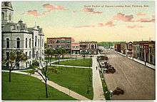 Old postcard, showing courthouse and commercial streets; several horse-drawn vehicles on street