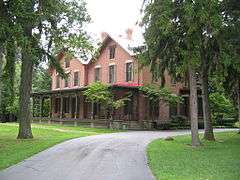 A large brick house surrounded by trees