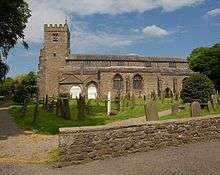 A stone church seen from the south, with a clerestory and an embattled west tower.