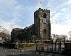 A stone church with a west battlemented tower