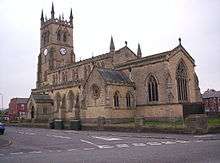 A large stone church with a battlemented clerestory and a pinnacled tower